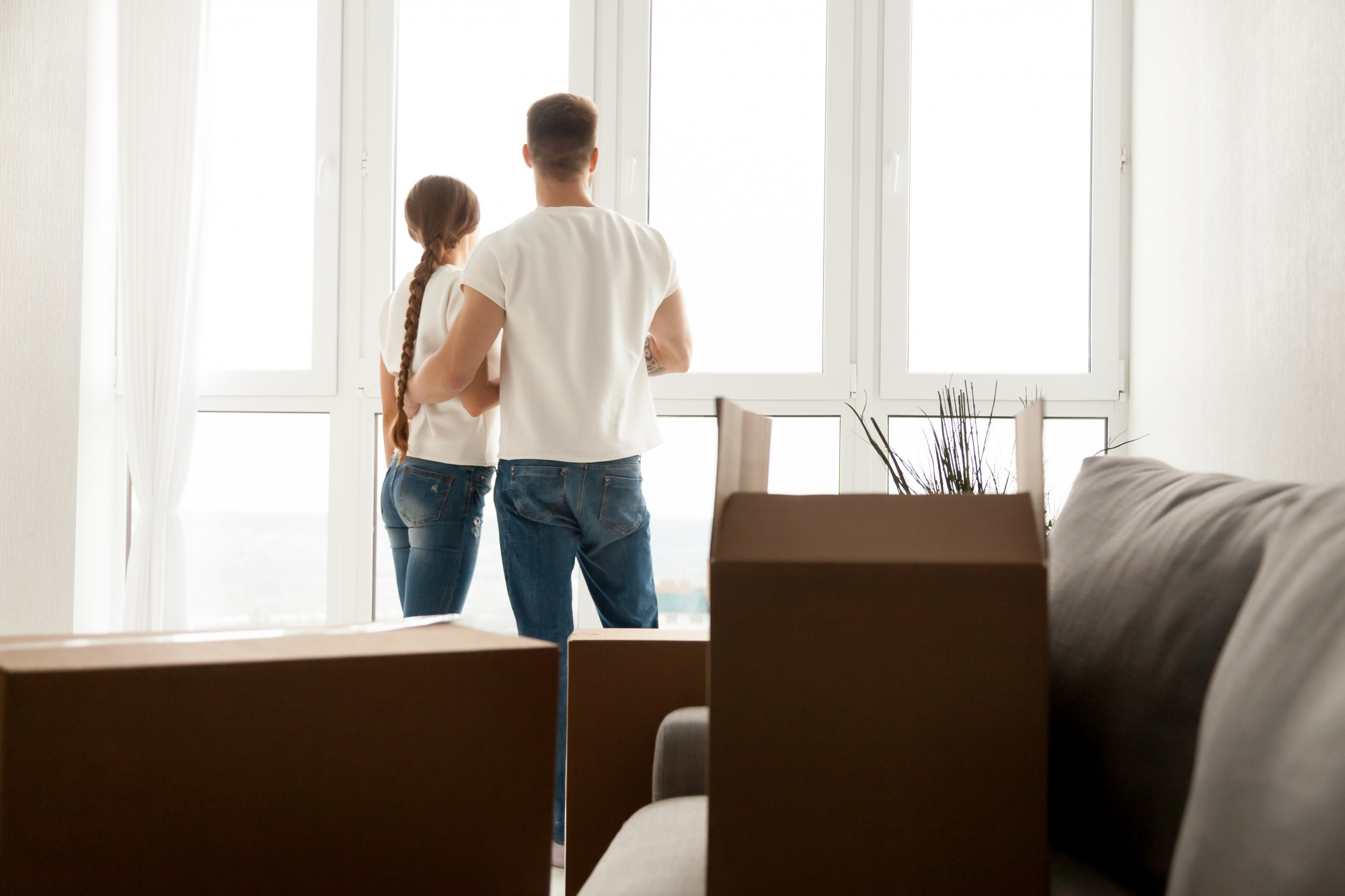 Vente Rapide - image d'un couple qui regarde par la fênetre et planifie son futur dans leur nouvelle maison